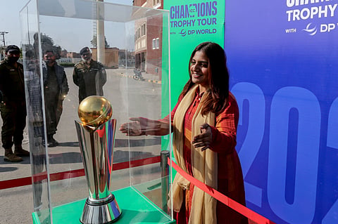 A woman looks at the 'ICC Champions Trophy' displayed outside the Multan Cricket Stadium during a ceremony in Multan on February 2.