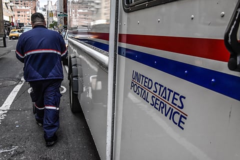 A USPS worker delivers packages in New York