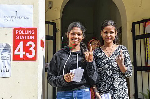 First-time voters show their fingers marked with indelible ink after casting their votes for the Delhi Assembly elections, at Lady Irwin School in New Delhi on Wednesday.