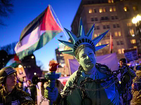 An activist dressed as the Statue of Liberty is pulled in shackles as they rally in support of Palestinians during the "Arrest Netanyahu at the White House Rally" near the White House in Washington, DC, on February 4, 2025.