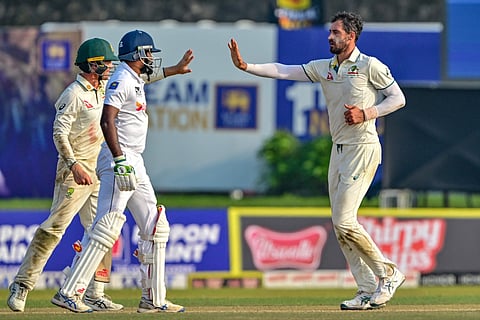 Australia's Mitchell Starc (right) celebrates with teammates after taking the wicket of Sri Lanka's Prabath Jayasuriya during the first day of the second Test cricket match at the Galle International Cricket Stadium in Galle on Thursday.
