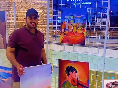 Saudi artist Hazam Al Shahrani with his paintings.
