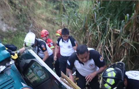Rescue workers are seen at the accident site where at least 31 people died when a bus fell into a ravine in Guatemala on Monday.