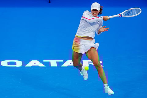 Iga Swiatek of Poland returns the ball to Maria Sakkari of Greece during their 2025 WTA Qatar Open match at the Khalifa International Tennis Complex in Doha on February 10.