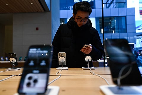 A man tests an iPhone in an Apple store in Beijing on February 13, 2025.