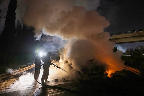 Firefighters extinguish a burning UNIFIL vehicle, set ablaze by protesters, on the road leading to Beirut’s international airport on February 14, 2025.