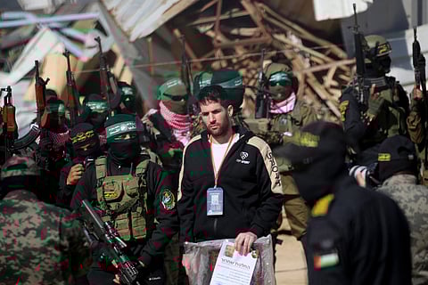 Palestinian militants escort Israeli-American hostage Sagui Dekel-Chen (C) before handing him over to a Red Cross team in Khan Yunis in the southern Gaza Strip on February 15, 2025, as part of the sixth hostage-prisoner exchange.