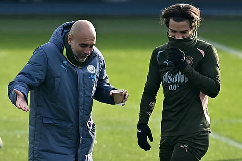 Manchester City's Spanish manager Pep Guardiola (left) jokes with English midfielder Jack Grealish during a training session at Manchester City's training ground in Manchester, north-west England, on February 18.