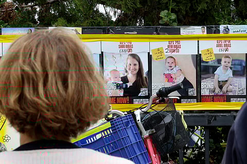 A woman looks at posters of Shiri Bibas and her two young sons, Kfir and Ariel outside the Tel Aviv Museum of Art, now informally called the "Hostages Square", on February 19, 2025.