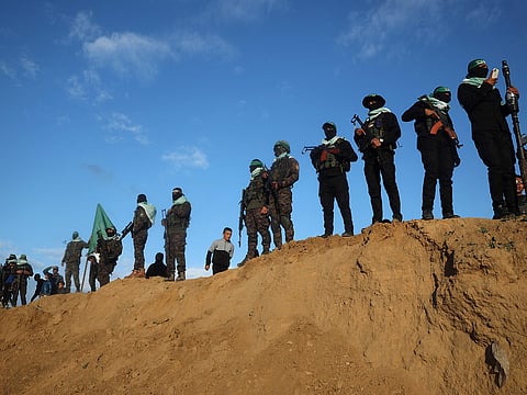 Palestinian militant group Hamas fighters stand at attention ahead of the handing over the bodies of four Israeli hostages in Khan Yunis in the southern Gaza on February 20, 2025.