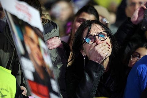 A woman reacts as crowds gather at hostage square in Tel Aviv, hours after the Palestinian group Hamas handed over the bodies of four hostages from the Gaza Strip on February 20, 2025.