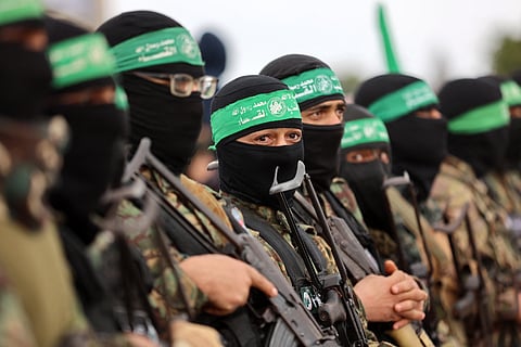 Hamas fighters gather at the site of the handing over of two Israeli hostages in Rafah in the southern Gaza Strip, as part of the seventh hostage-prisoner release on February 22, 2025.