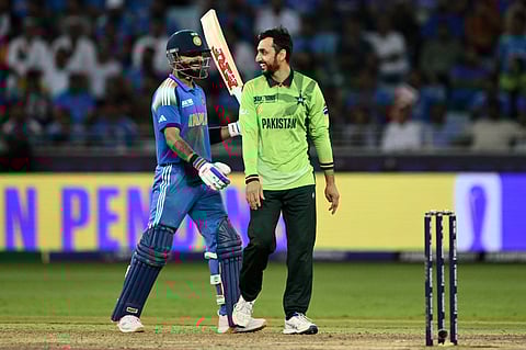 India's Virat Kohli (L) speaks with Pakistan's Salman Agha during the ICC Champions Trophy one-day international (ODI) cricket match between Pakistan and India at the Dubai International Stadium in Dubai on February 23, 2025.