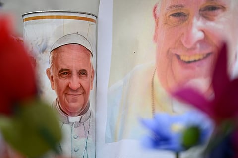 Flowers and portraits of Pope Francis are laid at the statue of John Paul II outside the Gemelli hospital where Pope Francis is hospitalized, in Rome.