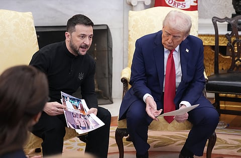 Ukrainian president Volodymyr Zelensky holds photos of Ukrainians who were captured by Russian troops as he meets with U.S. President Donald Trump in the Oval Office at the White House on February 28, 2025 in Washington, DC.