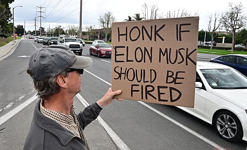 People participate in a "TeslaTakedown" protest against Elon Musk outside of a Tesla dealership in Irvine, California, March 1, 2025.