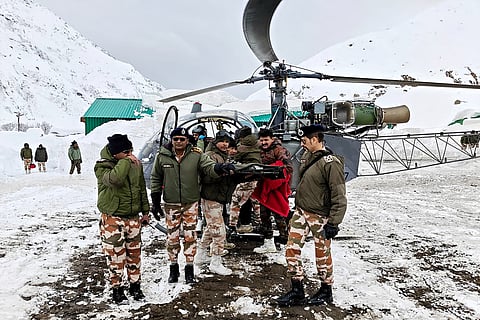 In this handout photograph taken on March 1, 2025 and released by the Department of Information and Public Relations (DIPR) Uttarakhand, security personnel carry a victim onto a helicopter during a rescue operation, a day after an avalanche hit a Border Roads Organisation (BRO) construction camp, as workers remain trapped under snow and debris near Mana village in the Chamoli district of India's Uttarakhand state.