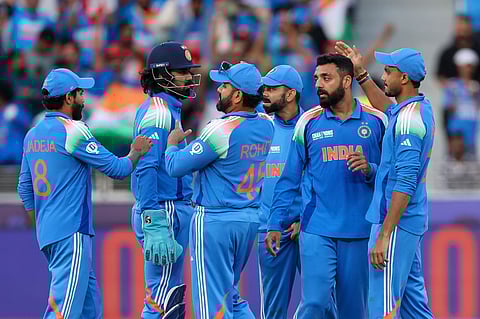 India's Varun Chakravarthy celebrates with teammates after taking the wicket of New Zealand's Will Young in the Champions Trophy match at Dubai International Stadium on Sunday.