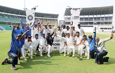 Vidarbha players and team staff pose for a picture with the trophy after winning the Ranji Trophy 2025 final match against Kerala, at VCA stadium in Nagpur on Sunday.