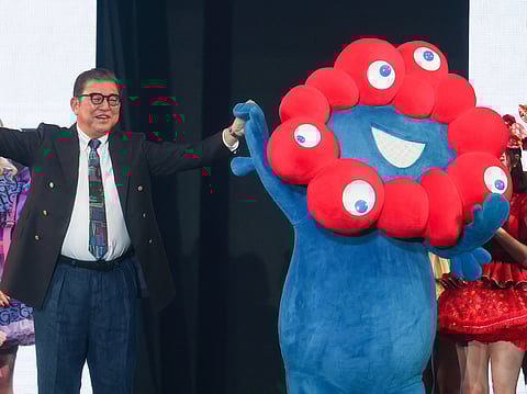 Japan's Prime Minister Shigeru Ishiba (L) stands with Myaku-Myaku (R), the mascot for the 2025 Osaka World Expo, as he models an outfit during a visit to the Tokyo Girls Collection fashion event in the Shibuya district of Tokyo on March 1, 2025.