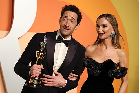 Adrien Brody (L) holds the Oscar for Best Actor in a Leading Role for "The Brutalist" next to girlfriend and actress Georgina Chapman as they attend the Vanity Fair Oscar Party