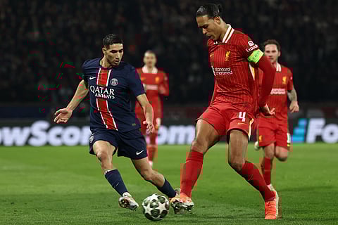 Liverpool's Dutch defender Virgil van Dijk (right) and Paris Saint-Germain's Moroccan defender Achraf Hakimi fight for the ball during the Uefa Champions League Round of 16 first leg football match at the Parc des Princes stadium in Paris on March 5.