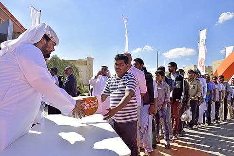 UAE Food Bank staff distribute food bags to workers. File photo