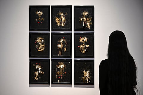 A person looks at AI artwork created by Pindar Van Arman’s Emerging Faces at a press preview for ‘Augmented Intelligence’ at Christie’s in New York City.