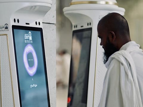 A worshipper approaches the Manara robot introduced in the Grand Mosque.