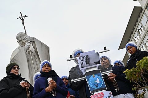 Nuns pray at the statue of John Paul II outside the Gemelli University Hospital where Pope Francis is hospitalized with pneumonia, in Rome.