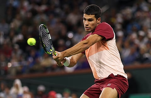 Carlos Alcaraz of Spain plays a backhand against Grigor Dimitrov of Bulgaria in their fourth round match during the BNP Paribas Open at Indian Wells Tennis Garden on March 12 in Indian Wells, California.