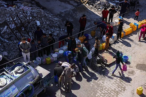 Palestinians queue for water next to a distribution truck at a displacement camp west of Jabalia city in the northern Gaza Strip.