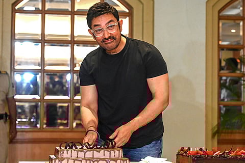 Bollywood actor Aamir Khan cuts a cake during his 60th pre-birthday celebrations, in Mumbai on March 13, 2025.