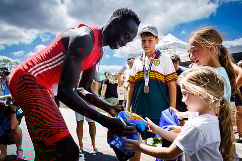 Australia's Gout Gout signs autographs after competing in the men's 200m heats during the Queensland State Championships in Brisbane on March 16.