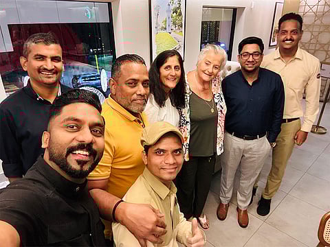 Sunita Williams and her mother Bonnie Pandya pose with Sumesh Govind (in yellow T-shirt), Najeeb Moidoo (behind him) and employees of Calicut Paragon in Dubai on November 8, 2023.