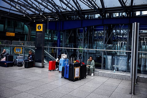 Passengers with their suitcases wait for news at Heathrow airport following its closure after a fire broke out at a substation supplying power of the airport, in Hayes, west London, on March 21, 2025.