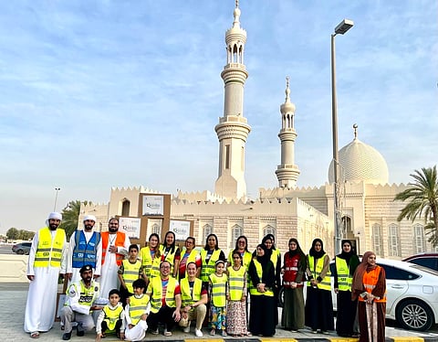 Volunteers at the Ramadan Aman initiative distribute iftar meals during iftar time at busy traffic intersections in Ajman.