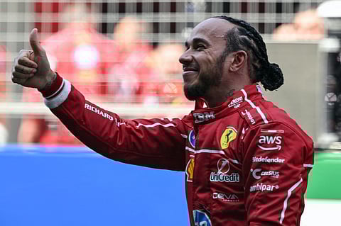 Ferrari's British driver Lewis Hamilton gives a thumbs up as he celebrates winning the sprint race of the Formula One Chinese Grand Prix at the Shanghai International Circuit in Shanghai on March 22.