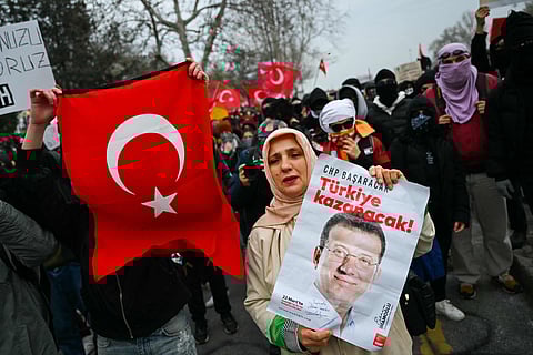 Protesters hold signs and Turkish flags during a rally in support of Istanbul mayor Ekrem Imamoglu on Sunday.