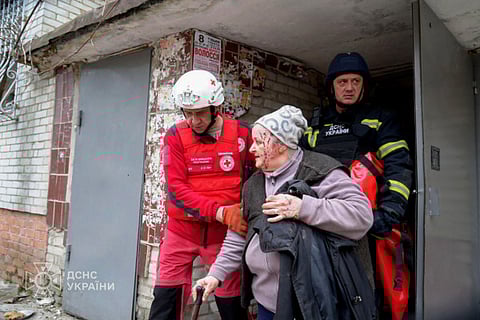 Ukrainian rescuers helping an injured woman evacuate a residential building following a missile attack in Sumy, northeastern Ukraine on March 25.