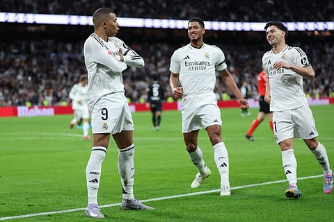 Real Madrid's French forward #09 Kylian Mbappe (left) celebrates with teammates after converting a penalty to score their first goal during the Spanish league football match against Club Deportivo Leganes SAD at the Santiago Bernabeu stadium in Madrid on March 29.