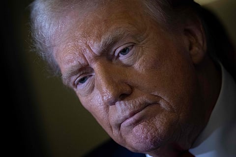 US President Donald Trump listens to a question while speaking to members of the press while returning to Washington, DC on Air Force One on March 30, 2025, in Fredericksburg, Virginia.