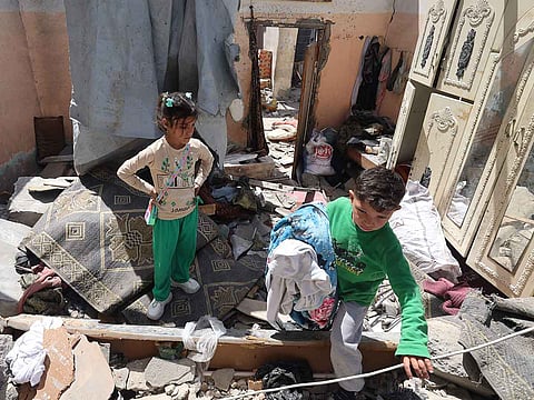 Palestinian children salvage items from the rubble of a house that was destroyed in an Israeli airstrike in Khan Yunis in the southern Gaza Strip on March 31, 2025.
