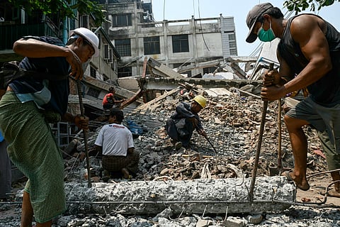 Workers clear up the rubble of a collapsed building in Mandalay on April 2, 2025, five days after a major earthquake struck central Myanmar.