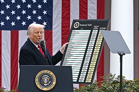 US President Donald Trump delivers remarks on reciprocal tariffs as US Secretary of Commerce Howard Lutnick holds a chart during an event in the Rose Garden entitled "Make America Wealthy Again" at the White House in Washington.