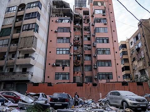 Men inspect the scene at the site of an Israeli strike on a building in Beirut's southern suburbs on April 1, 2025.