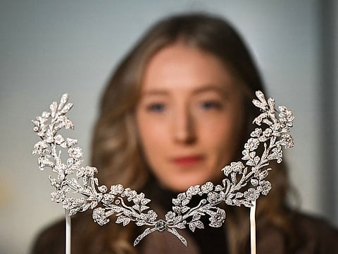 A visitor looks at the Lily Stomacher Brooch dated from 1906 and owned by US industrialist heiress and congresswoman Mary Scott Townsend during a photocall for the forthcoming Cartier exhibition at the V&A (Victoria and Albert) museum in London.