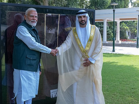 Sheikh Hamdan and Narendra Modi pose for a photo in front of the memorabilia