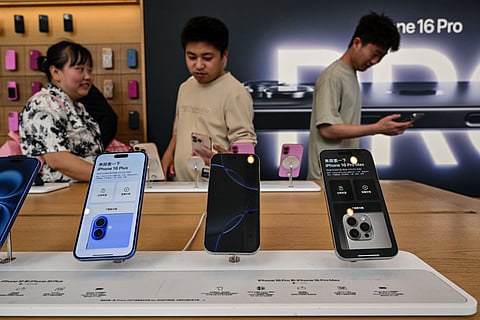 People browse for Iphone 16 displayed in a Apple store in the Huangpu district in Shanghai on April 11, 2025.