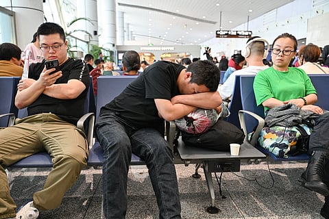 Passengers wait at the Yiwu airport in Yiwu, China’s eastern Zhejiang province early on April 12, 2025, as scores of flights were cancelled due to extreme winds forecast in several parts of the country over the weekend.